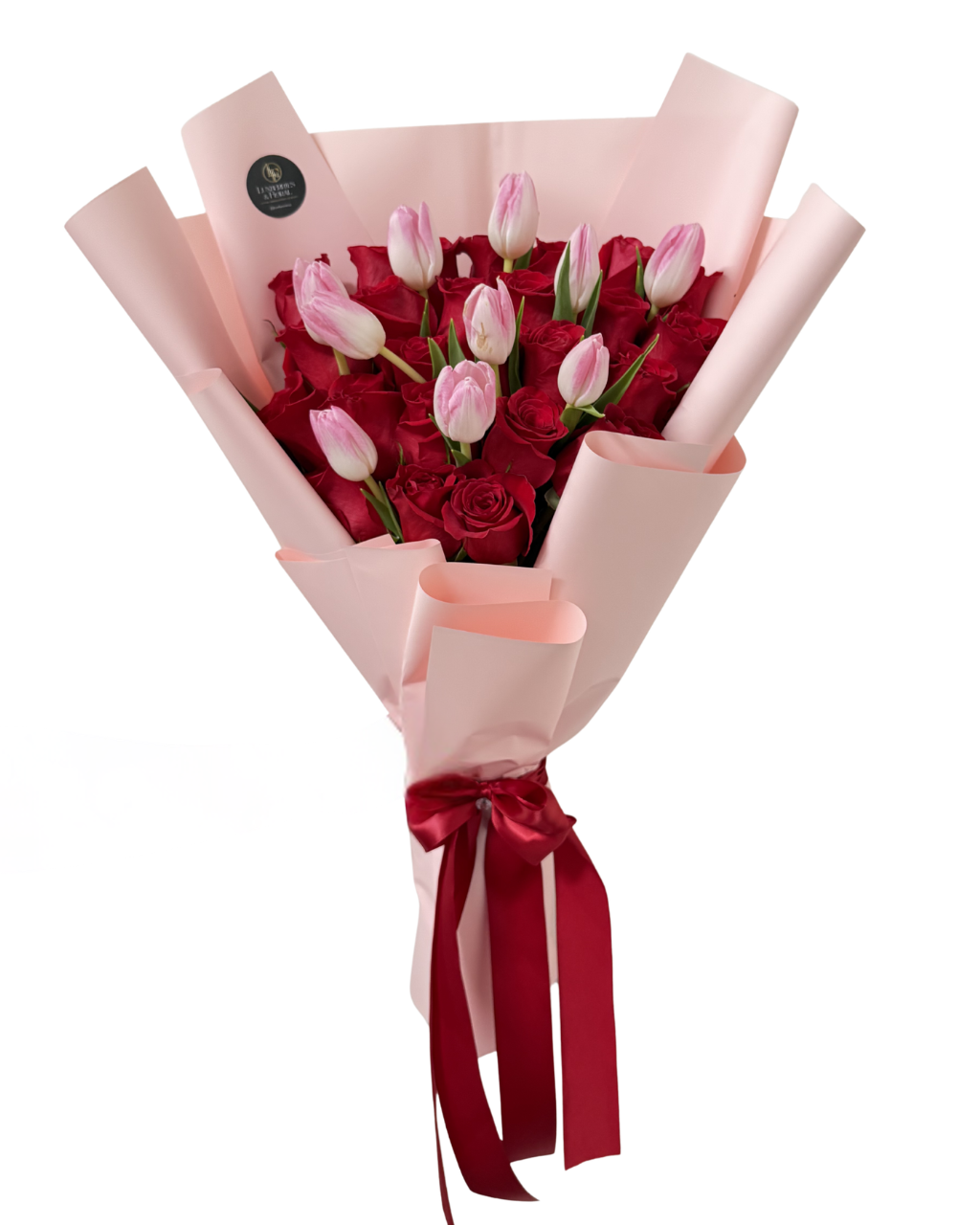 Bouquet of red and pink roses wrapped in pink paper with a red ribbon on a white background
