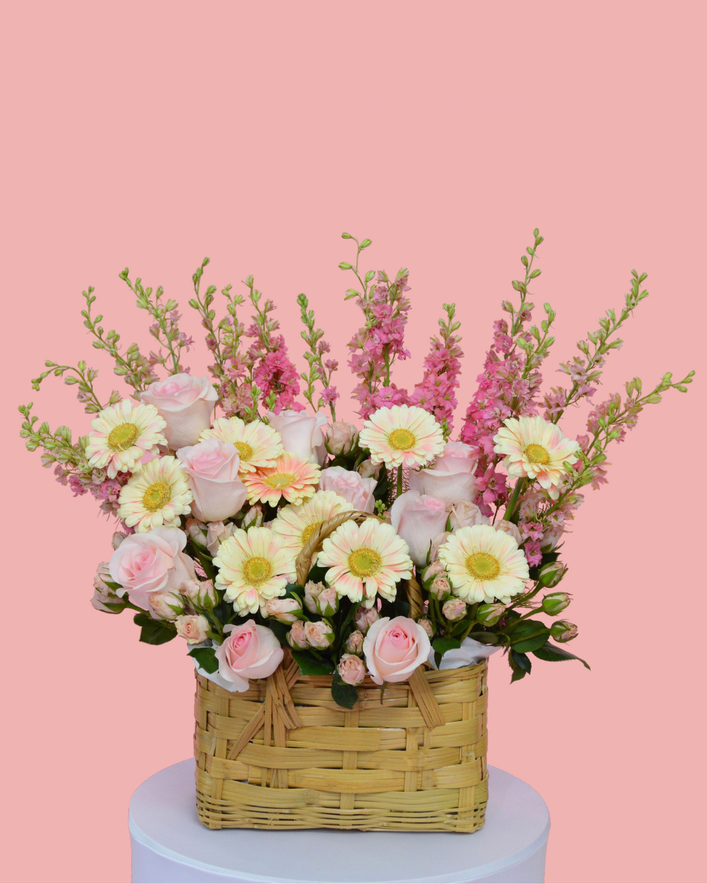 Floral arrangement in a woven basket on a white background