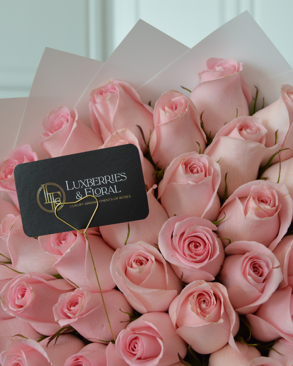 Bouquet of pink roses with a Luxberries & Floral card inside.