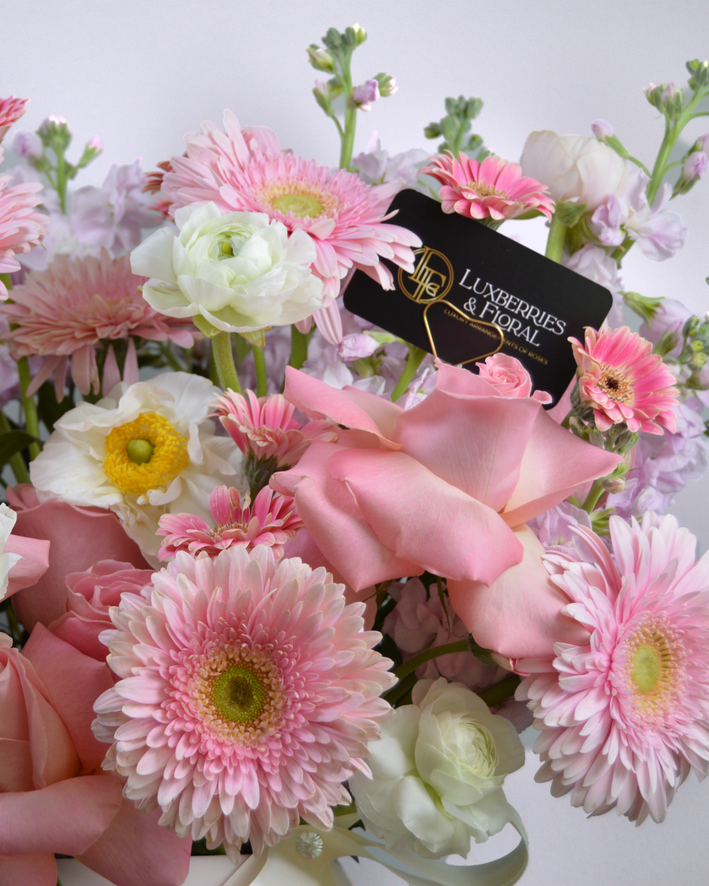 Bouquet of pink and white flowers with a 'Lunberries & Floral' tag.