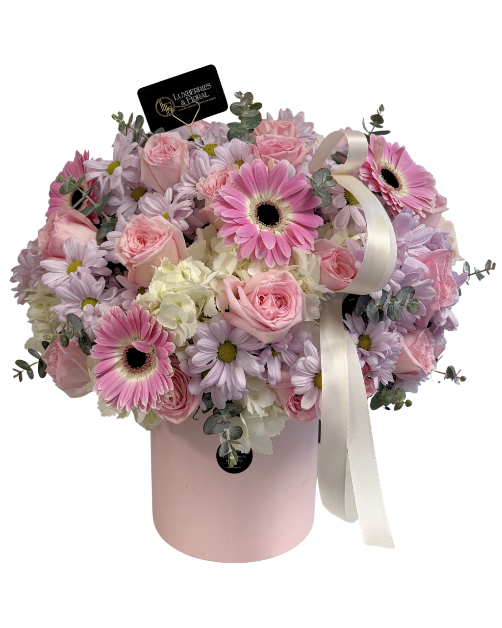 Pink and white flower arrangement in a box with a visible brand tag on a white background