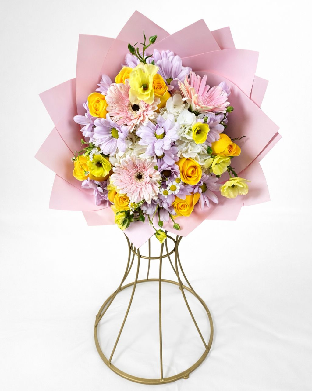 Bouquet of flowers wrapped in pink paper on a white background