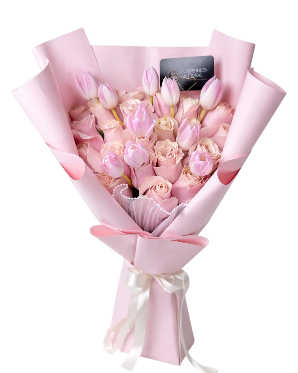 Bouquet of pink and white flowers wrapped in pink paper with a card on a white background