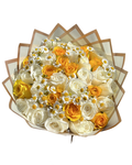 A round floral bouquet featuring white and yellow roses, yellow daisies, and baby's breath, wrapped in clear and beige paper with a geometric pattern, isolated on a white background.