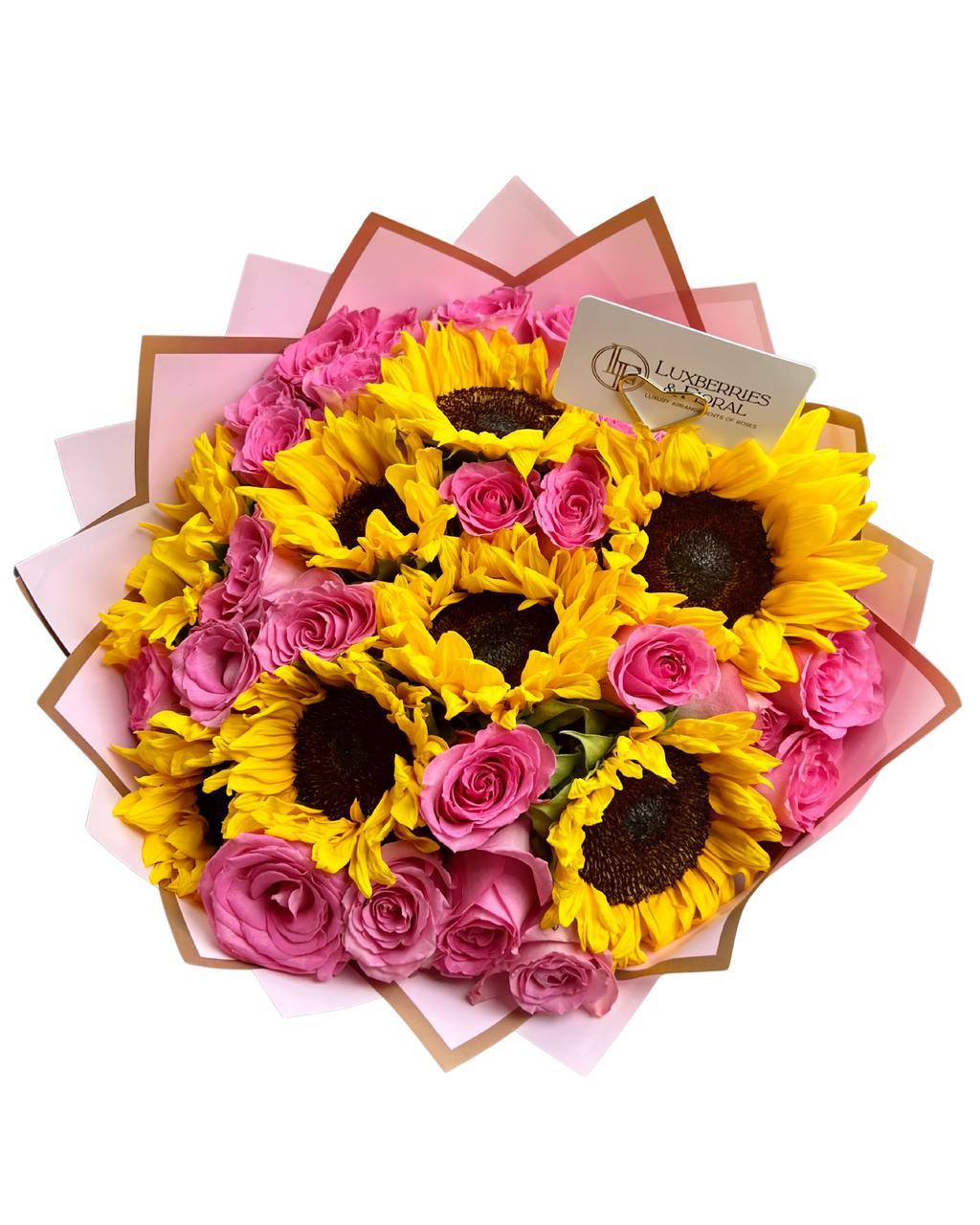 A vibrant flower bouquet featuring bright yellow sunflowers and pink roses, wrapped in pink paper with brown edges and a small card from Flowers Direct.
