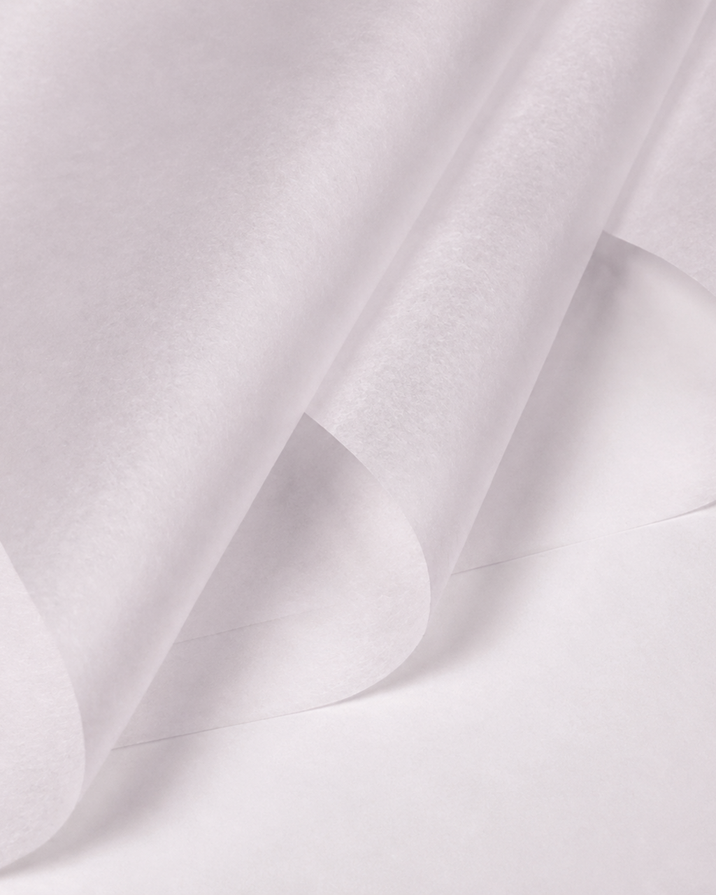 A close-up of a white semi-transparent sheet material, possibly parchment paper or wax paper, shown with soft folds and shadows.
